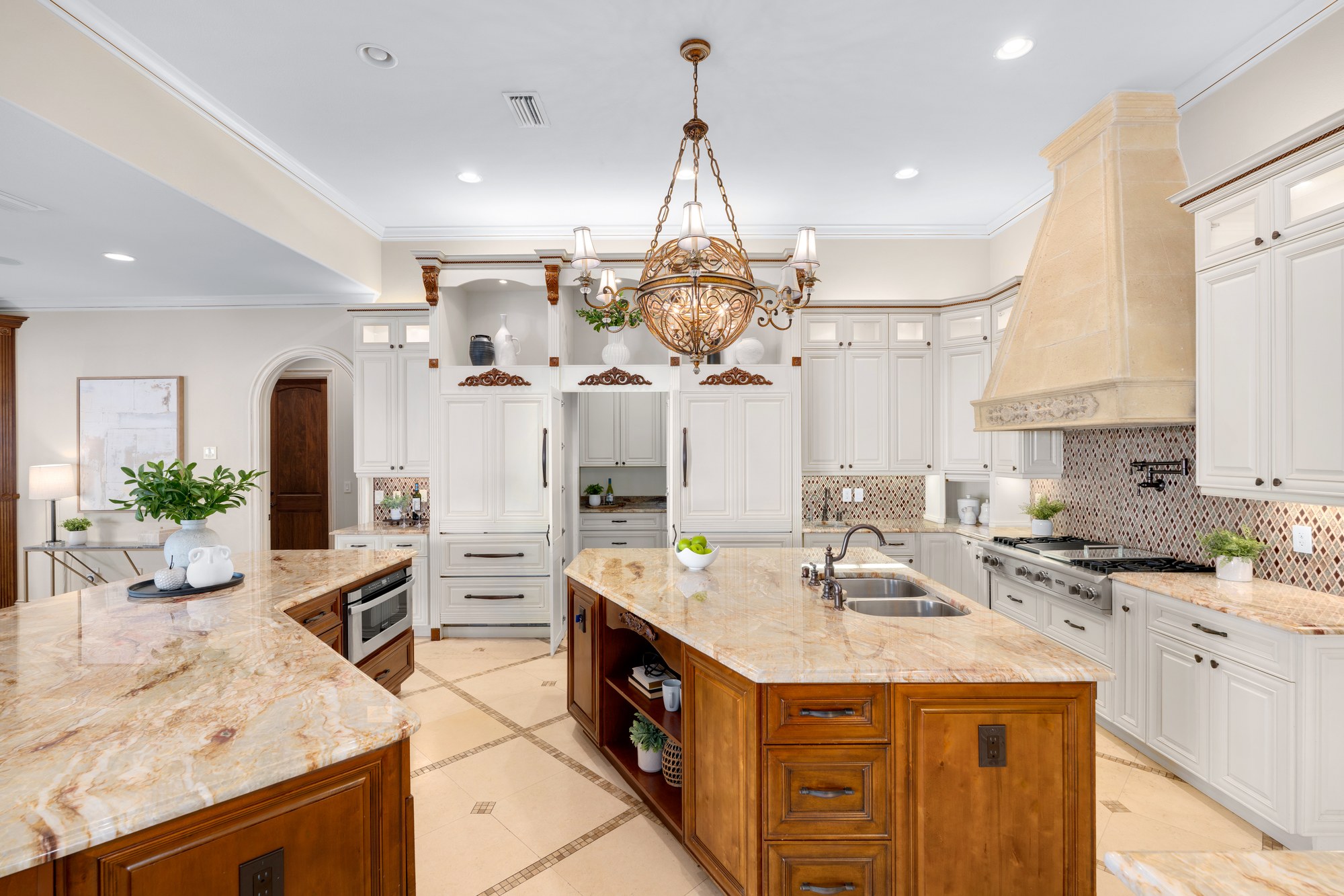 The chef's kitchen with a custom hood, center island, and natural stone countertops