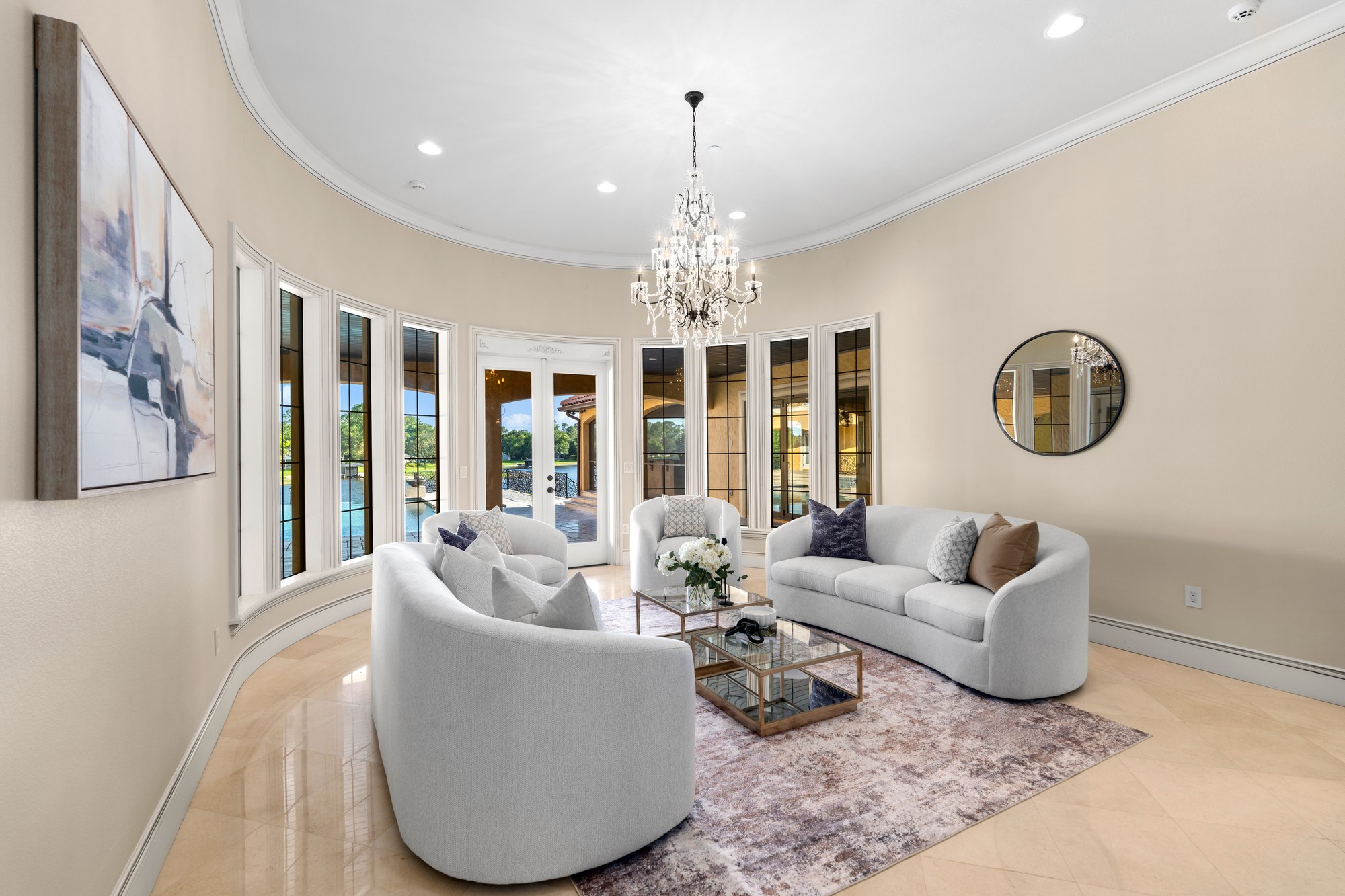A formal living room with a curved wall of windows overlooking the lake