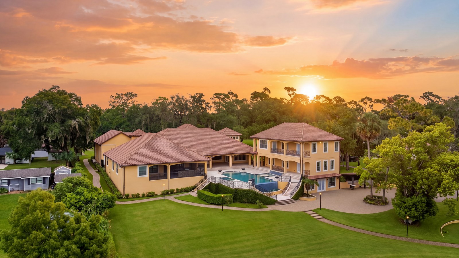 Sunset aerial view of the estate, pool, and grounds