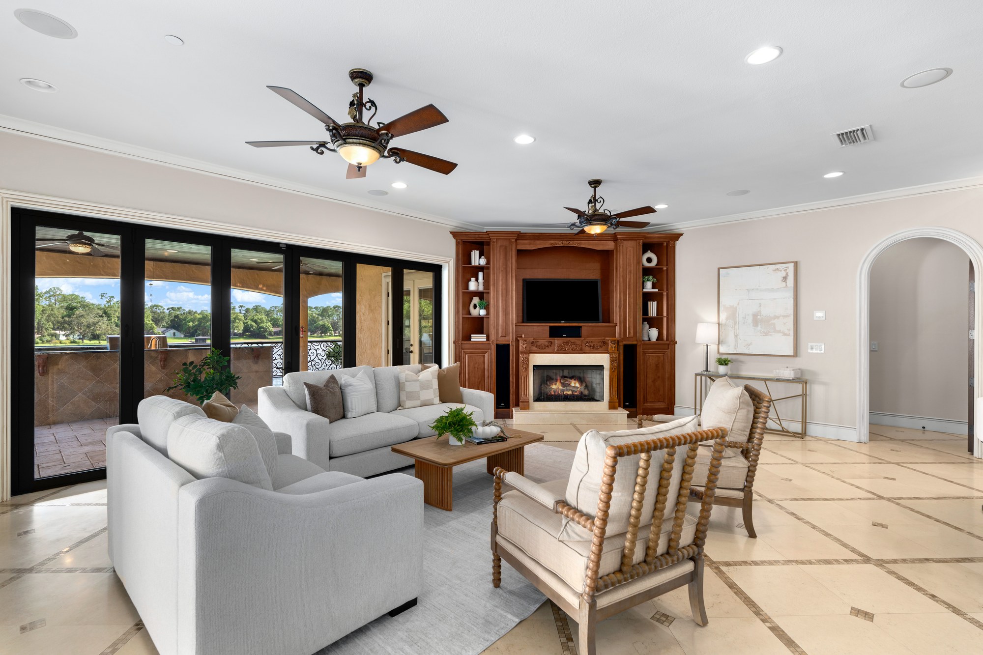 The family room lounge with built-in media cabinetry and sliding glass doors to the lanai